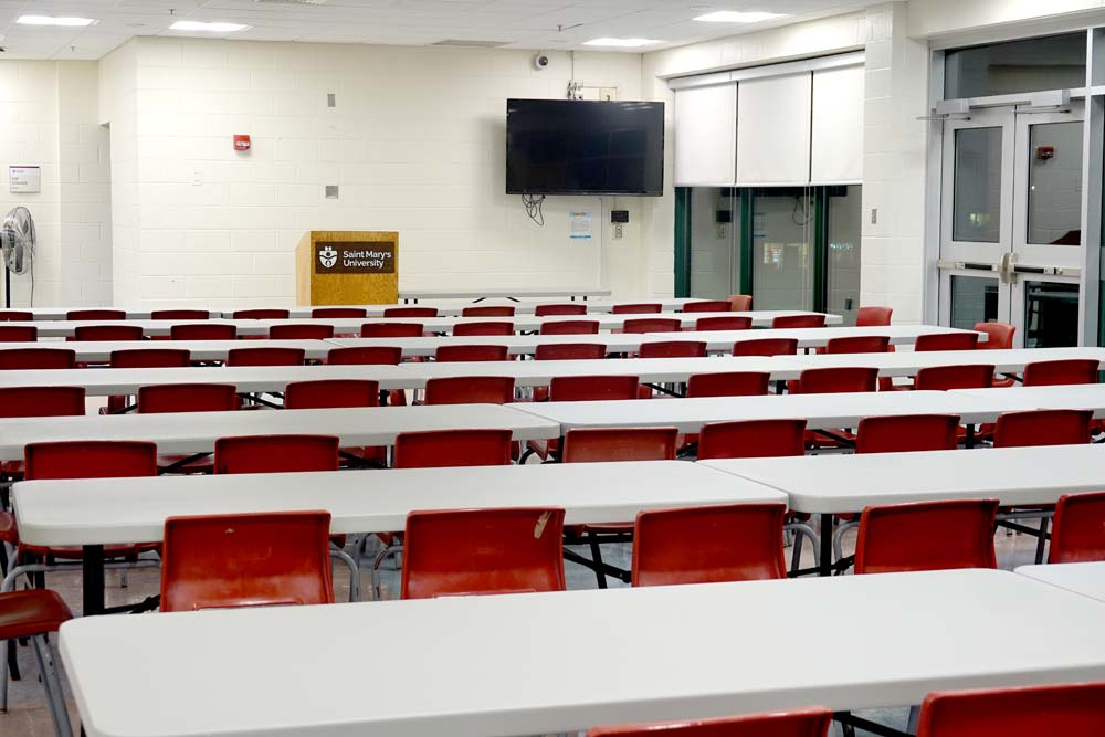 Courtside Lounge with rows of table s and chairs facing a podium