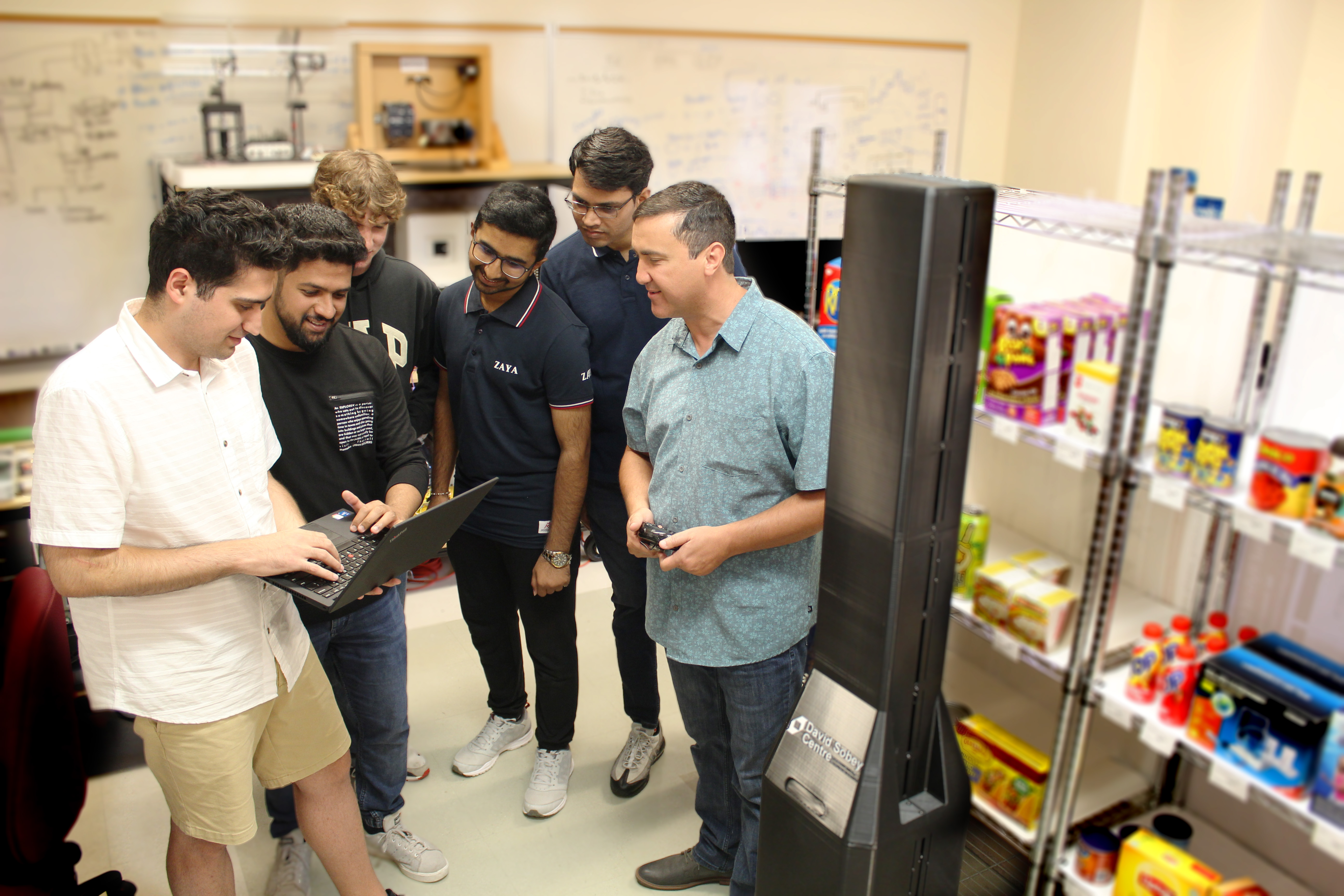 Professor with students who build retail robot