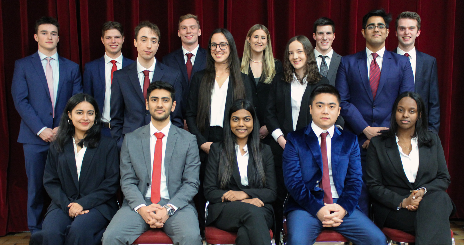 Group of students posing for a photo, front group is sitting on chairs